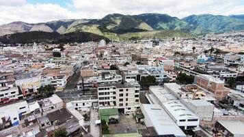 A cityscape with a mix of residential and commercial buildings, a prominent 'Mobil Super' sign, and a mountainous backdrop.