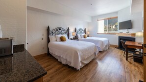A hotel room with two beds, a desk, a television, and a window with a view of buildings. - Luxury hotel room in Canyons Village, mountain view, outdoor pool, hot tub, near hiking & biking (Park City)
