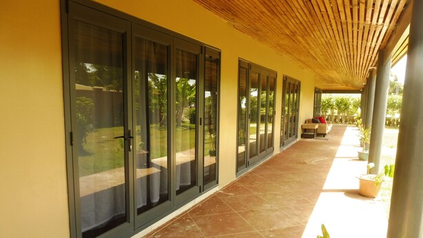 Un pasillo cubierto con puertas correderas de vidrio que dan a un patio amueblado al aire libre.
