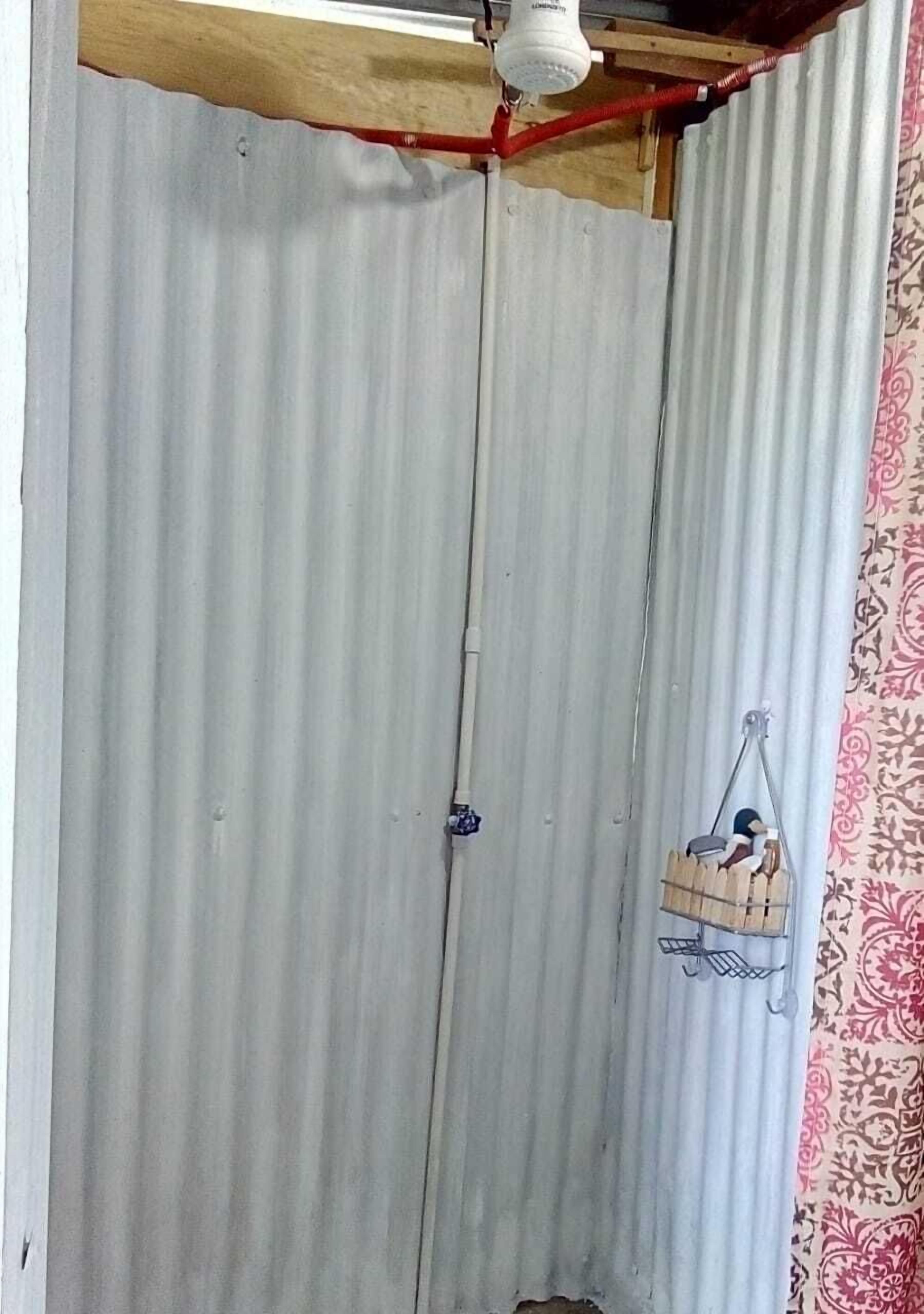 A corrugated metal wall with a wooden beam structure at the top.
