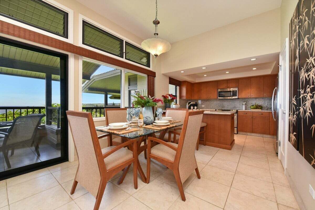 Una cocina moderna con comedor, ventanas amplias y vistas al exterior.