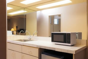 Una cocina moderna equipada con microondas, lavaplatos y pileta.