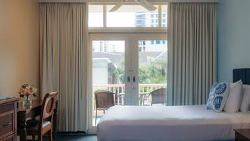 Habitación de hotel con cama, escritorio, silla y vistas al exterior.