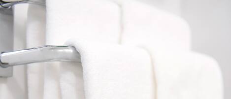 Une serviette blanche est suspendue à un porte-serviettes métallique.