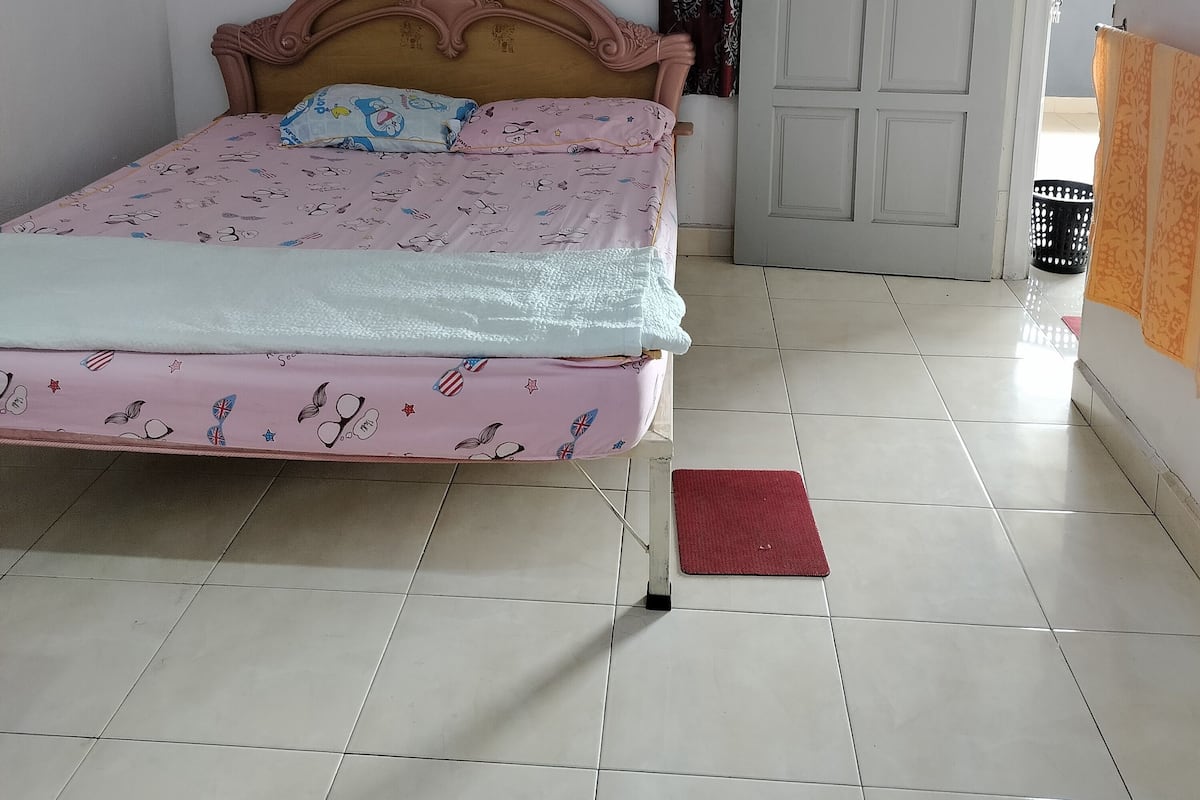 Une chambre à coucher avec un lit, une porte et un sol carrelé.