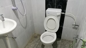 A bathroom with a white toilet, a sink, and a shower. - 223 Taman Malaysia (Alor Setar)