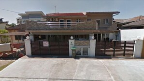 A modern two-story house with a stone facade, a gated entrance, and a driveway. - 223 Taman Malaysia (Alor Setar)