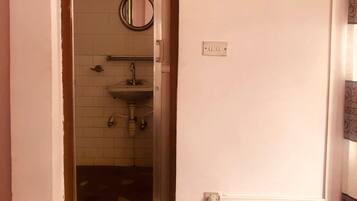 Une salle de bain équipée d’un lavabo, d’un miroir et d’un porte-serviettes.