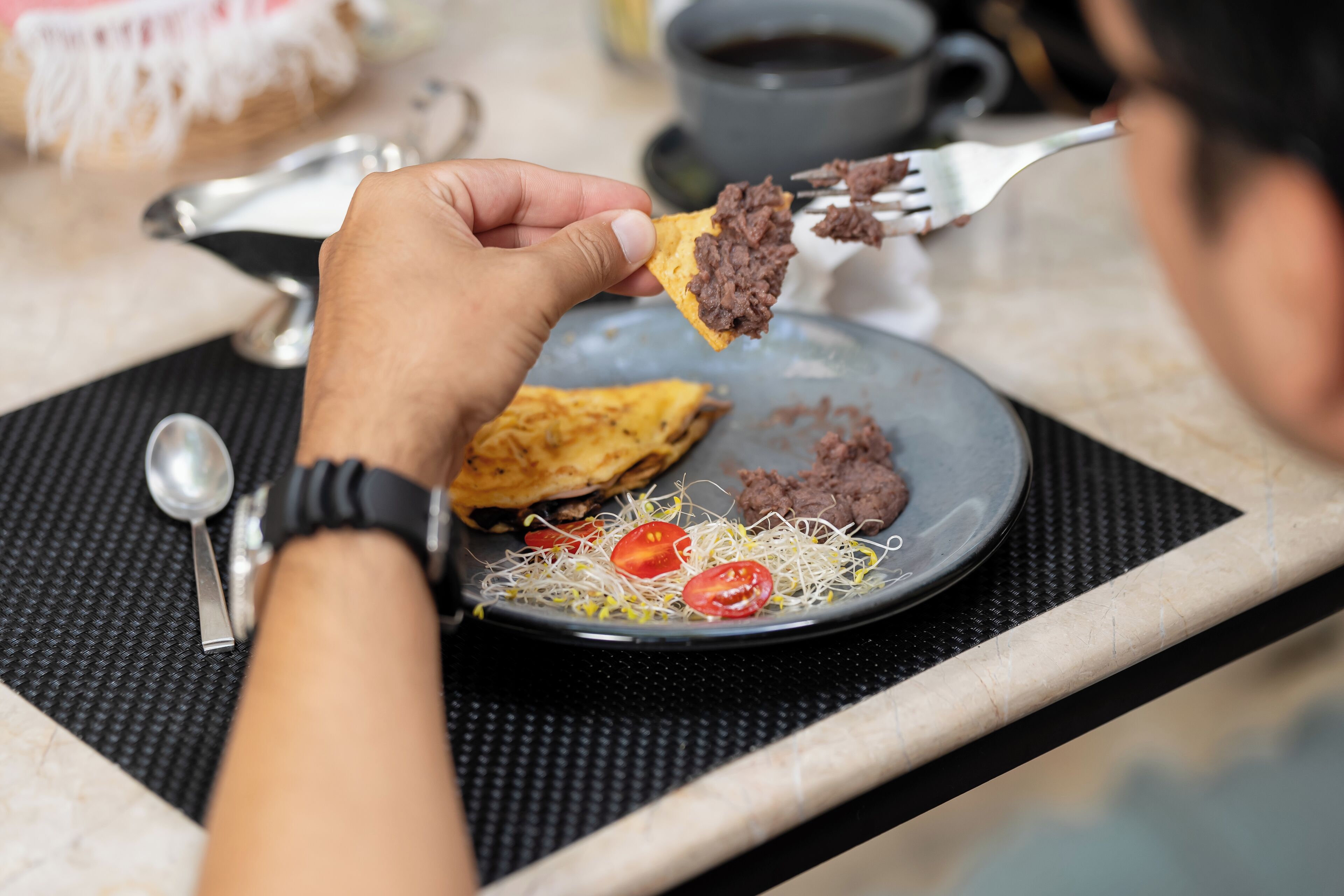 Una persona sosteniendo un tenedor con comida en un plato.