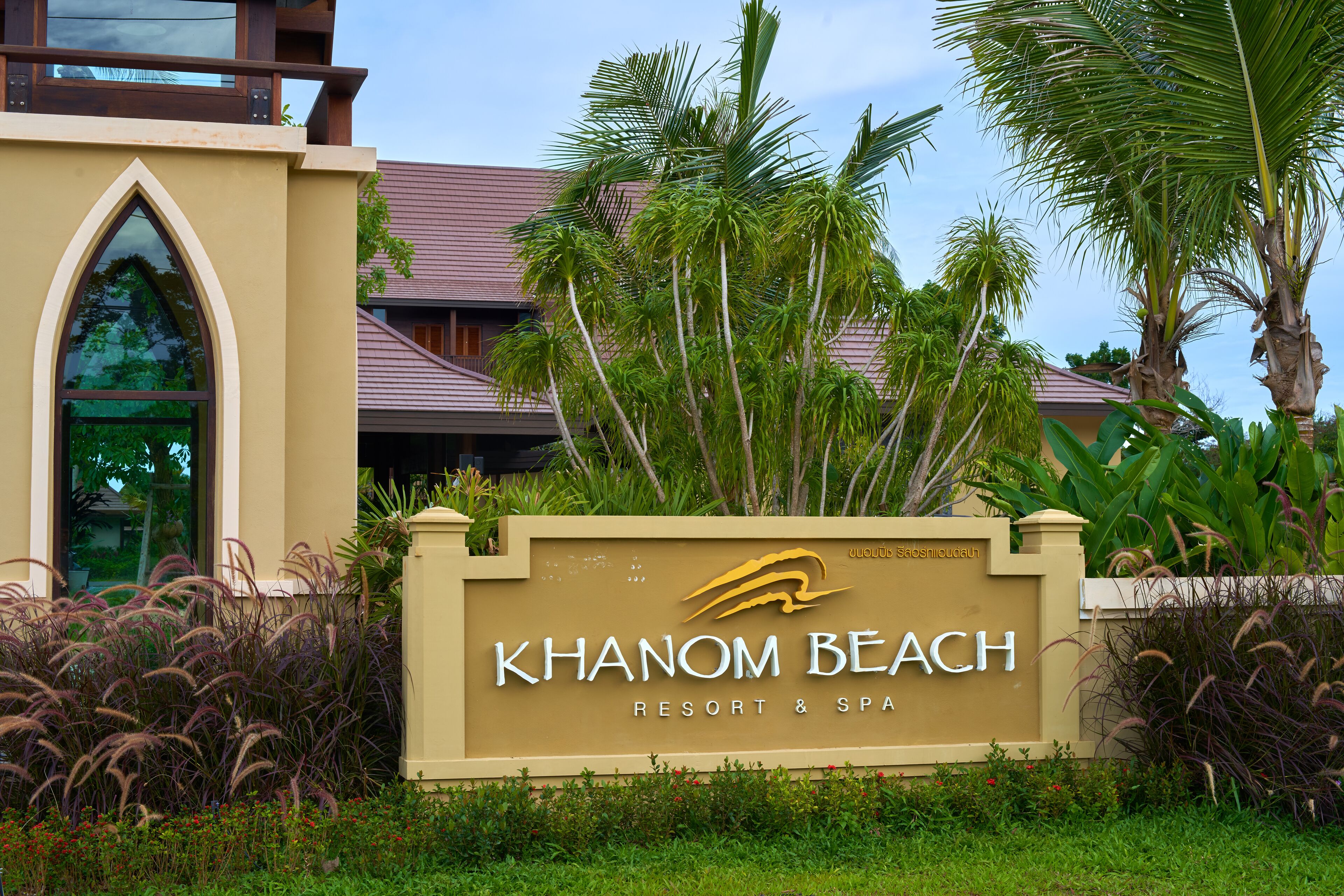 A sign for Khao Nang Beach Resort & Spa with a modern building in the background.