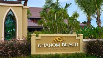 A sign for Khao Nang Beach Resort & Spa with a modern building in the background.