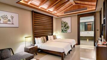 Una habitación de hotel moderna con techo de madera, una cama grande, un sofá y un baño visible a través de una puerta abierta.