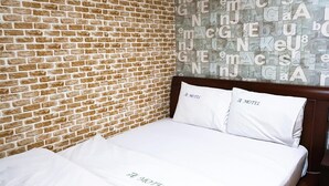 A hotel room with a brick wall and a bed with white bedding. - Gumi A Motel (Gumi)