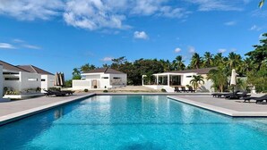 A swimming pool with lounge chairs and a building in the background.