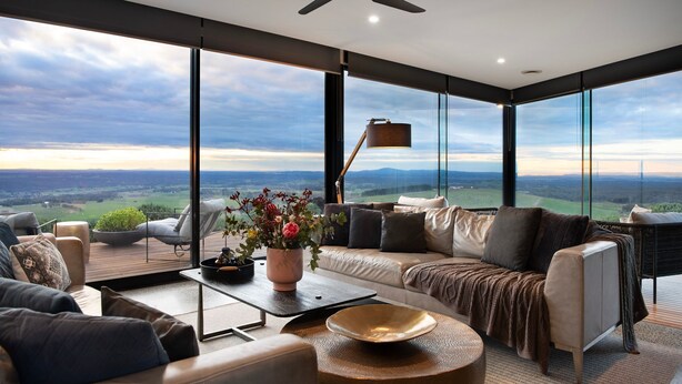 A modern living room with a large window offering a scenic view of the countryside. - Sky High: stunning, iconic, dramatic (Mount Franklin)