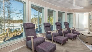 En modern inredning med stora fönster, ett trädäck och sittplatser.