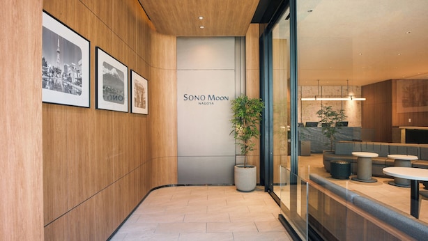 A modern hotel lobby with wooden paneling, framed photographs, a reception desk, and seating areas. - SONO Moon Nagoya  (Nagoya)