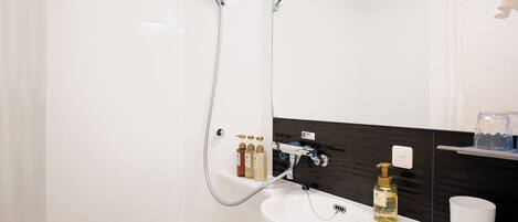 A modern bathroom with a bathtub, a sink, a mirror, and a shower.