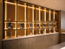 A modern reception desk with a series of illuminated panels and framed artwork.