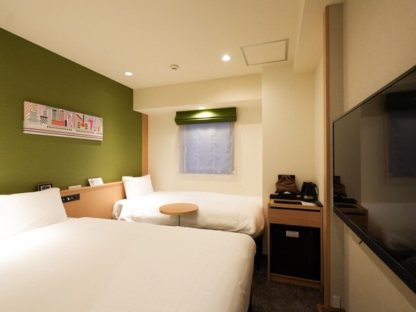A hotel room with two beds, a small table, a TV, and a window with a curtain. - SONO Moon Nagoya  (Nagoya)