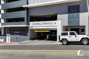 A building with a sign reading "LEEUWENSTR. ENTRANCE" and a vehicle parked in front.