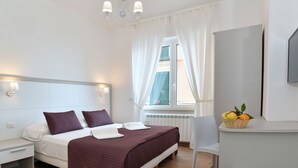 Una camera da letto moderna con un letto, comodini, una scrivania e una finestra con tende.