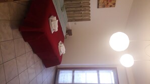 Una stanza con un letto, una finestra e un termosifone a parete.