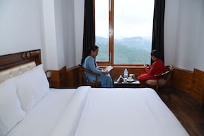 Enjoy a restful stay in this cozy room with a large bed and scenic mountain views.
