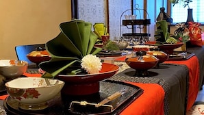 Un comedor tradicional japonés con esteras de tatami, mesas bajas y una variedad de platos y utensilios.