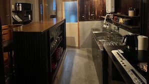 Una cocina moderna con armarios de madera, una isla central e iluminación colgante.