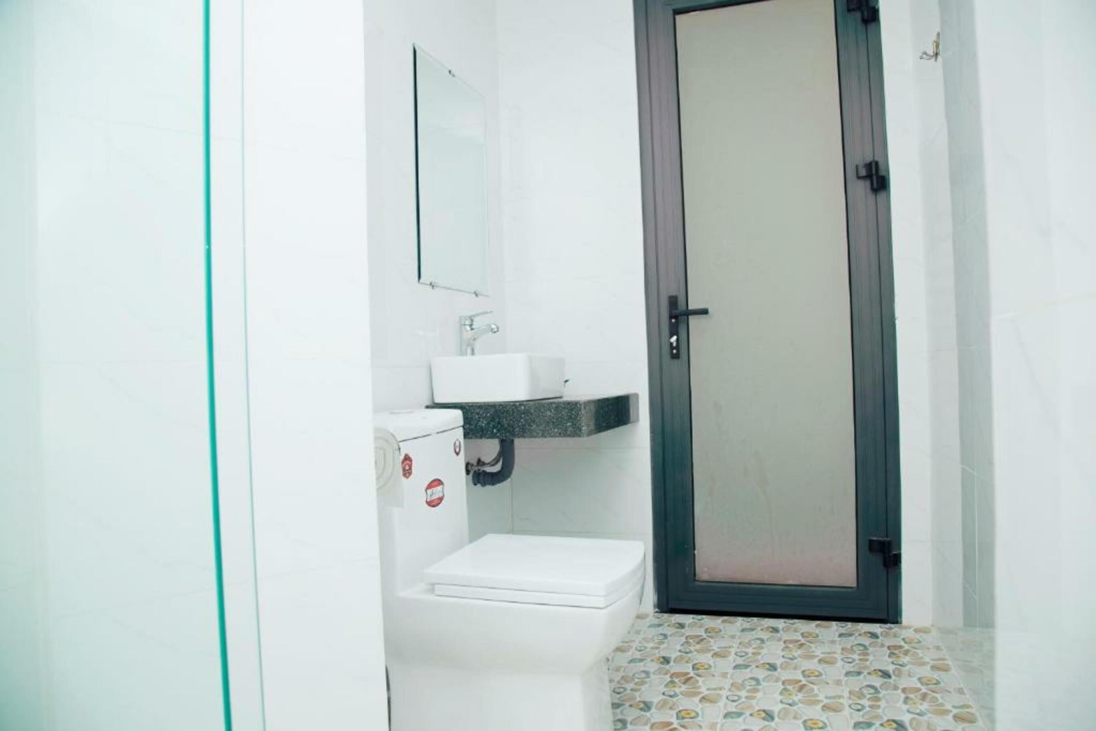Un baño pequeño con inodoro, lavamanos y espejo.