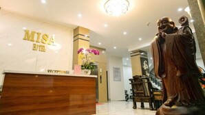 A reception desk with a statue of a seated figure, a chandelier, and a sign reading "MISA HOTEL". - Misa Hotel (Quy Nhon Nam)