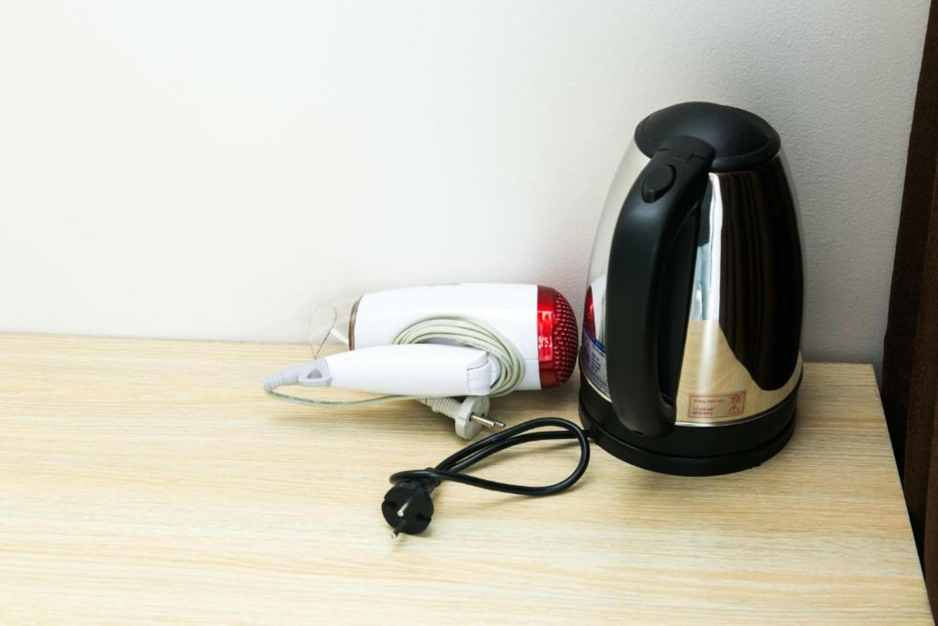 A kettle and a power cord on a wooden surface.