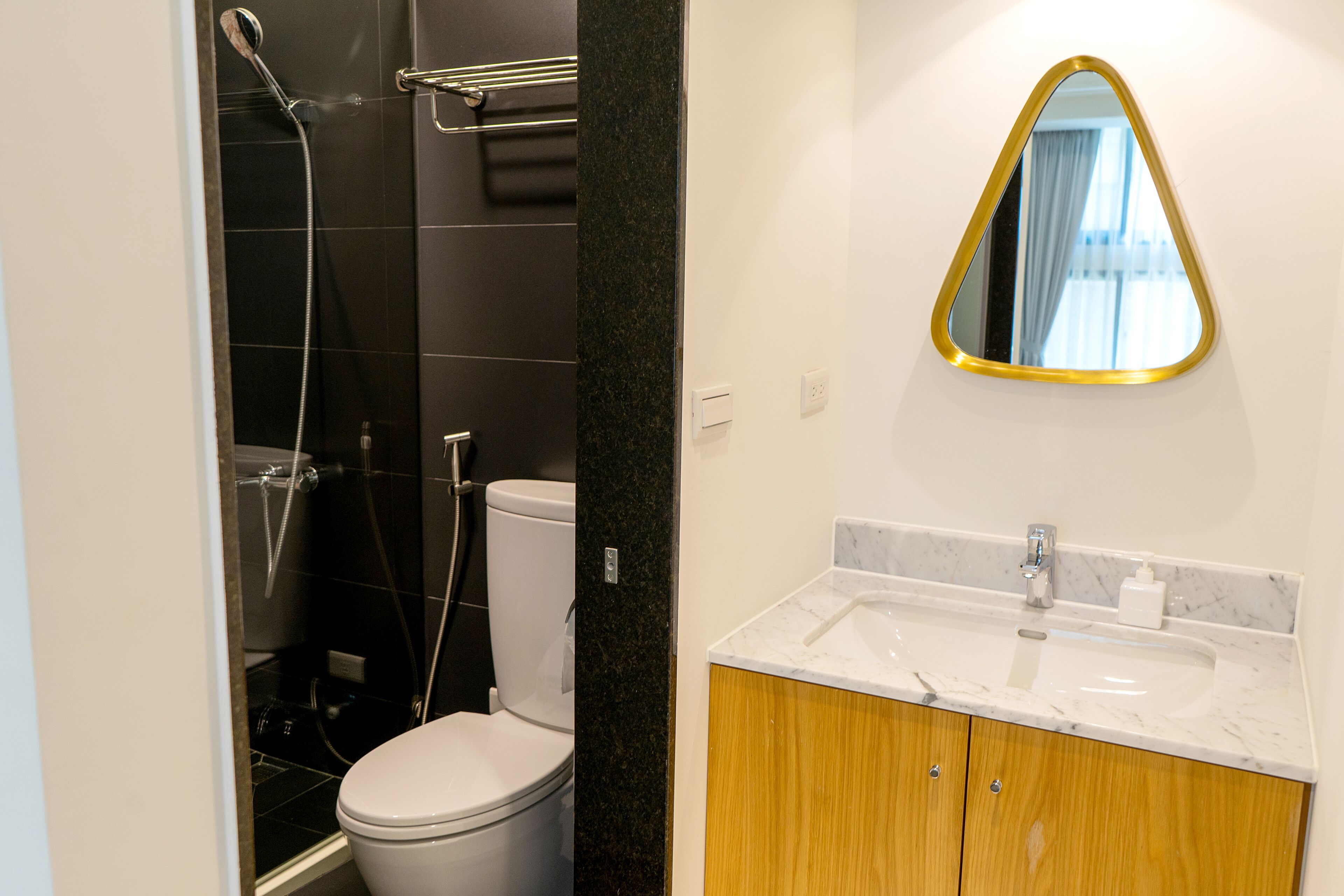 Un baño moderno con inodoro, ducha y tocador con espejo.