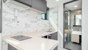 A modern kitchen with marble backsplash, a built-in scale, and a sleek countertop. - I Stayed Pension Yeosu (Yeosu)