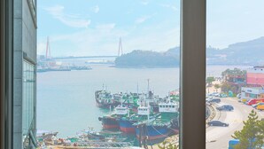 A view of a harbor with boats, a bridge, and a coastal town. - I Stayed Pension Yeosu (Yeosu)
