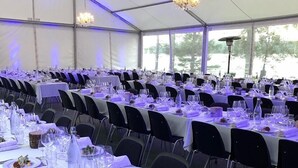 A tented dining area with tables set for a meal, each with plates, cutlery, and glasses. - Björkudden Hotell & Restaurang (Sandoverken)