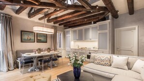 Amplia sala de estar con una mesa de comedor, sofá y cocina al fondo.