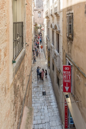 A narrow street with stone pavement, historic buildings, and a crowd of people. - Princ Heritage Rooms (Split)