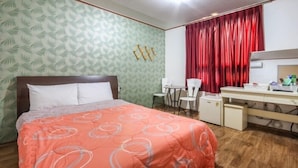 A bedroom with a bed, a desk, a chair, and a red curtain. - Royal Motel (Gwangju)
