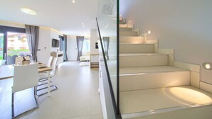Um interior moderno com escada, sala de jantar e área de estar.