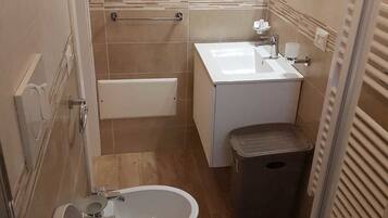 Ein Badezimmer mit Toilette, Bidet, Badewanne und Waschbecken.