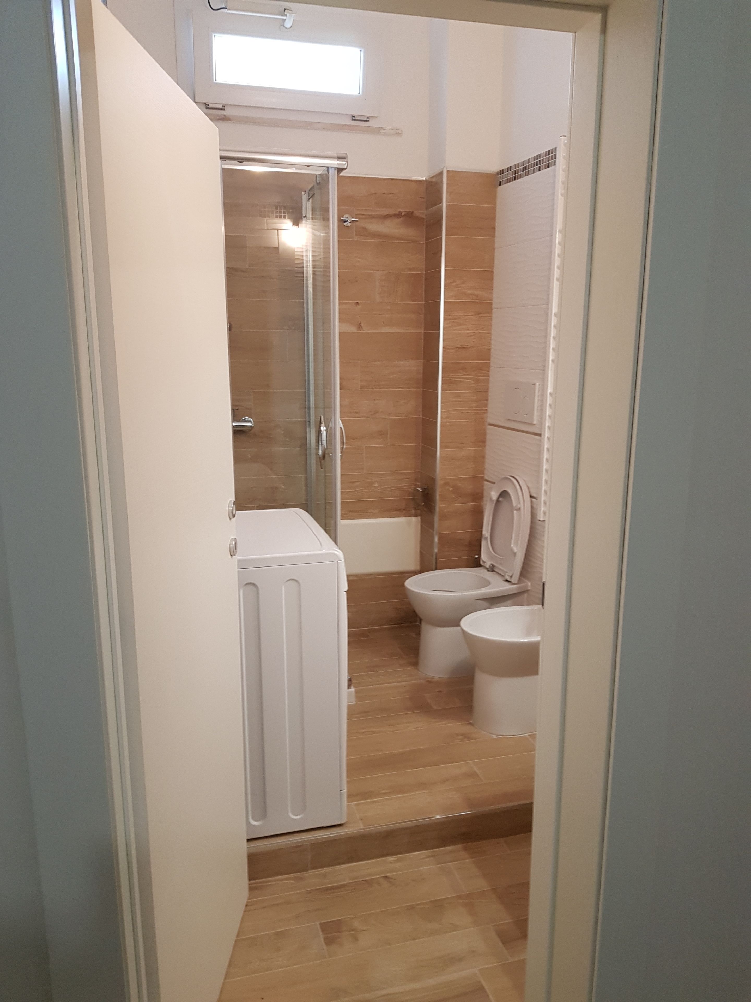 A bathroom with a shower, toilet, and bidet.