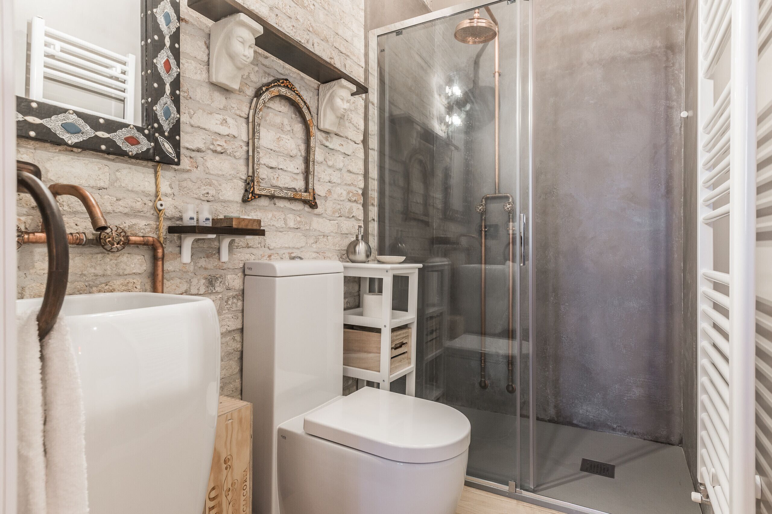 A bathroom with a white bathtub, a toilet, and a glass-enclosed shower.