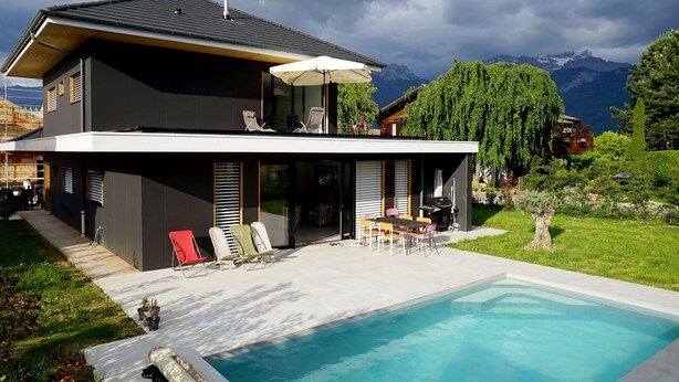 A modern two-story house with a swimming pool, outdoor seating, and a mountain view. - VILLA OSSATURE NEW WOOD WITH SWIMMING POOL in residential area (Saint-Jorioz)