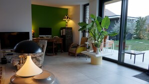 A modern living room with a large TV, a desk, and a comfortable seating area. - VILLA OSSATURE NEW WOOD WITH SWIMMING POOL in residential area (Saint-Jorioz)