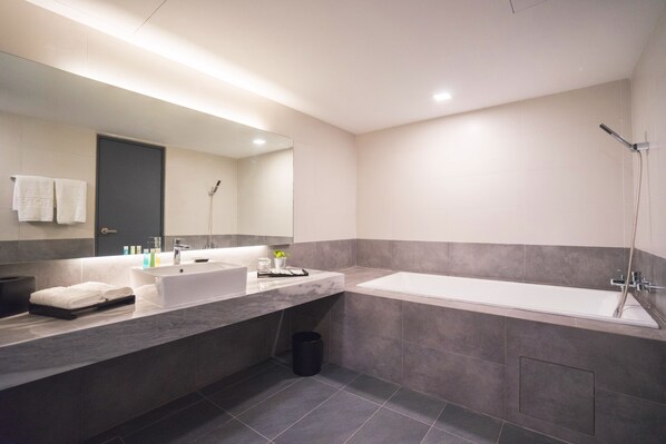 A modern bathroom with a large mirror, two sinks, a bathtub, and a shower. - Z Hotel Johor (Johor Bahru)
