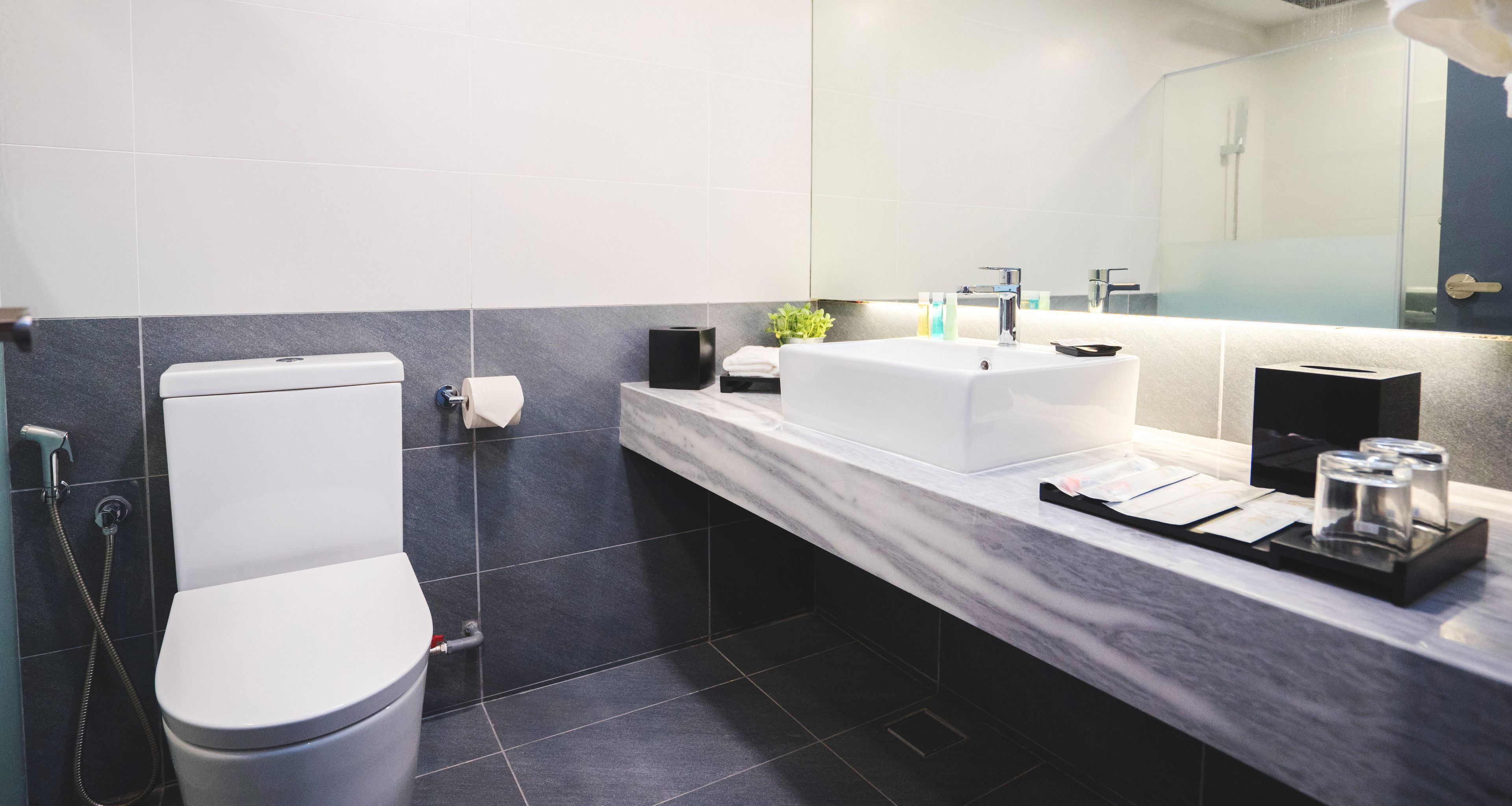 Un baño moderno con inodoro, lavamanos y ducha.