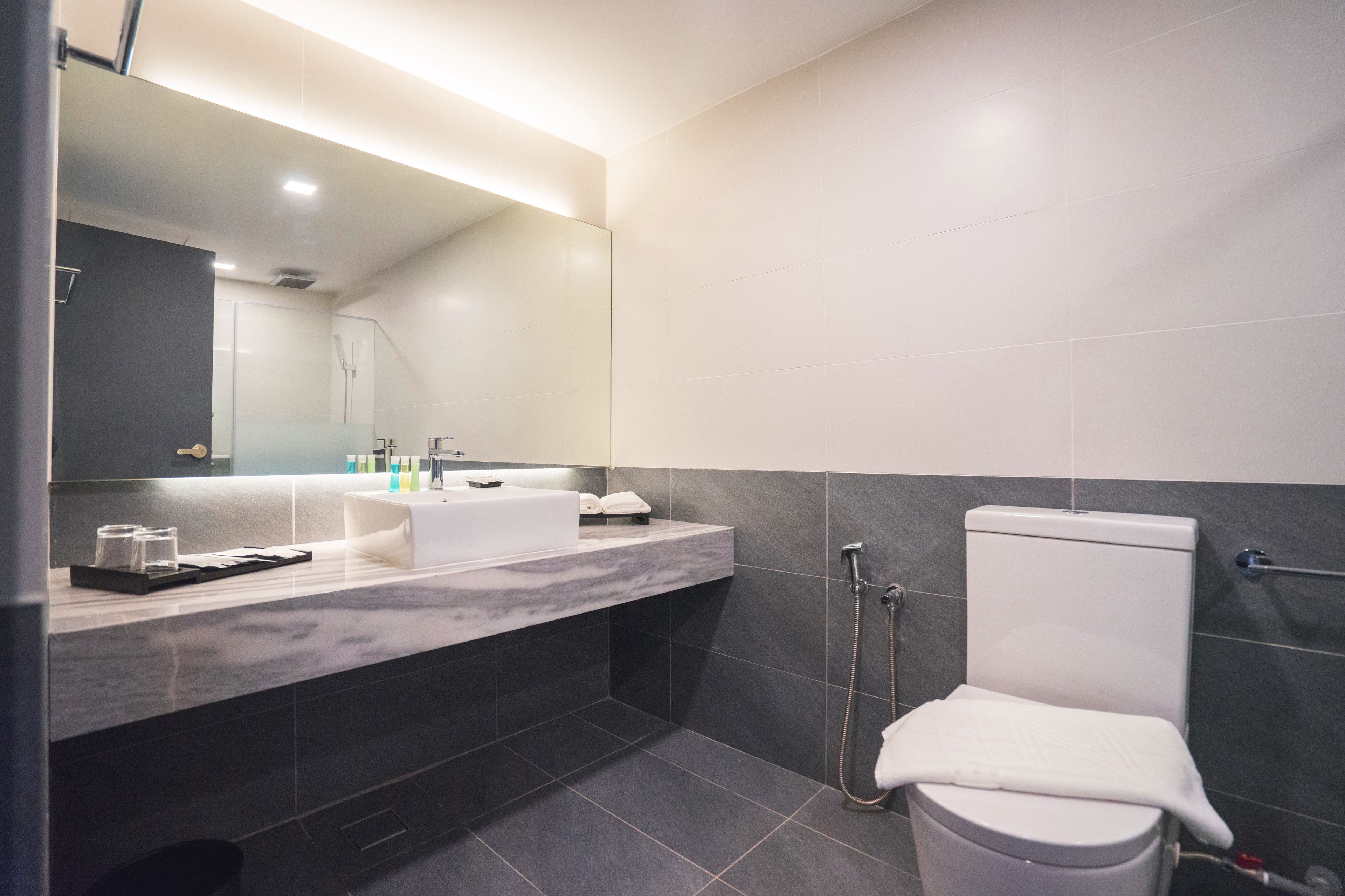 Un baño moderno con un tocador doble lavamanos, inodoro y ducha.