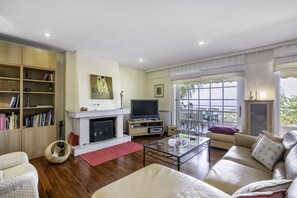 Departamento, vista al mar | Sala de estar | Televisión de pantalla plana, chimenea y reproductor de DVD